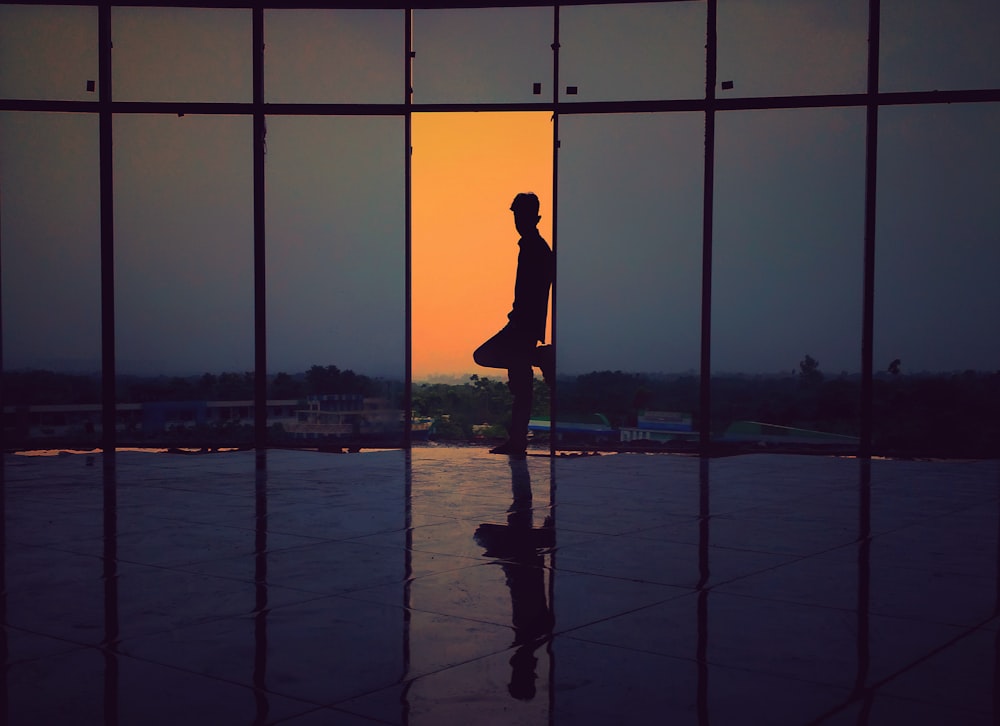 silhouette of man leaning on wall