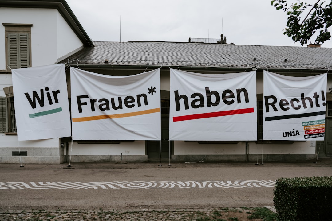 4 white tarpaulins with prints hanging besides white house