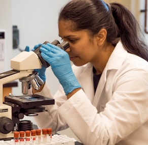 woman looking on microscope inside room