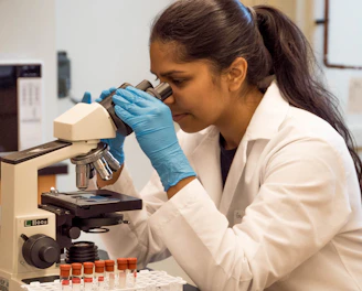 woman looking on microscope inside room