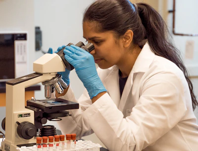 woman looking on microscope inside room