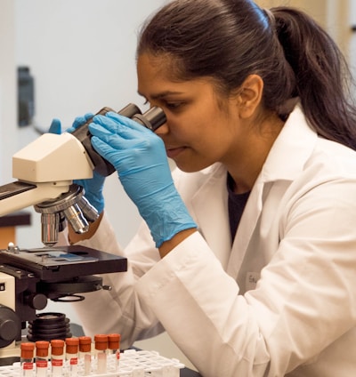 woman looking on microscope inside room