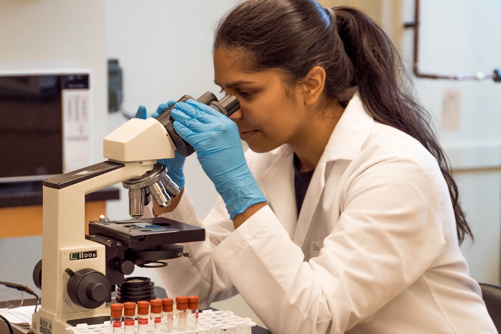 donna che guarda al microscopio all'interno della stanza