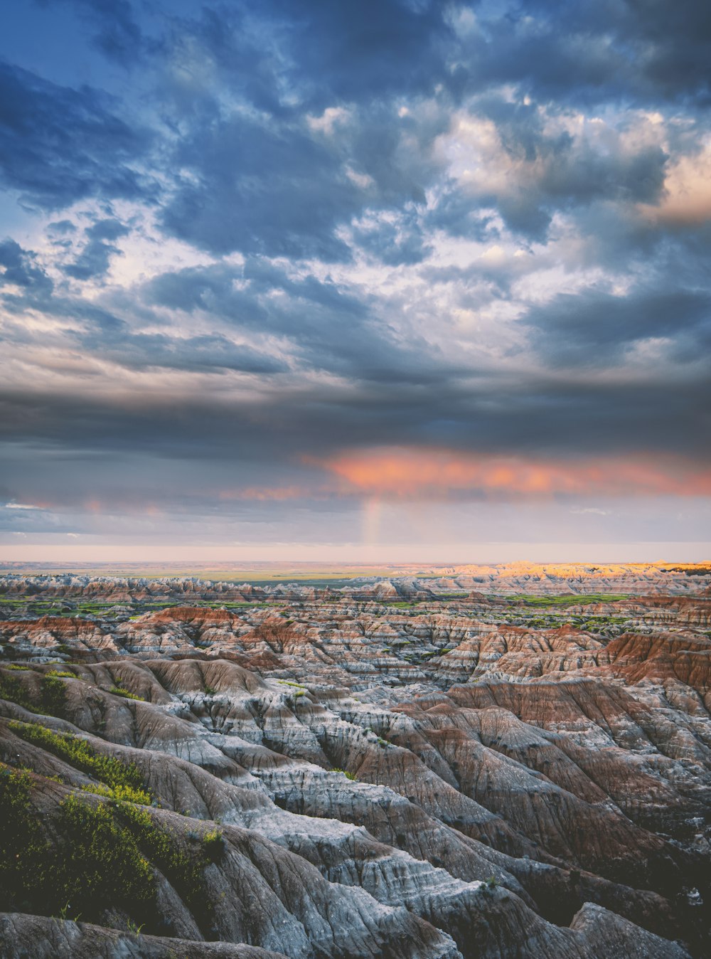 the sun is setting over the rocky terrain