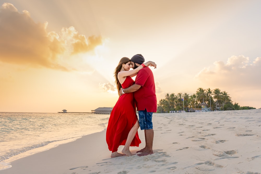 woman facing man while standing and hugging each other near seashore