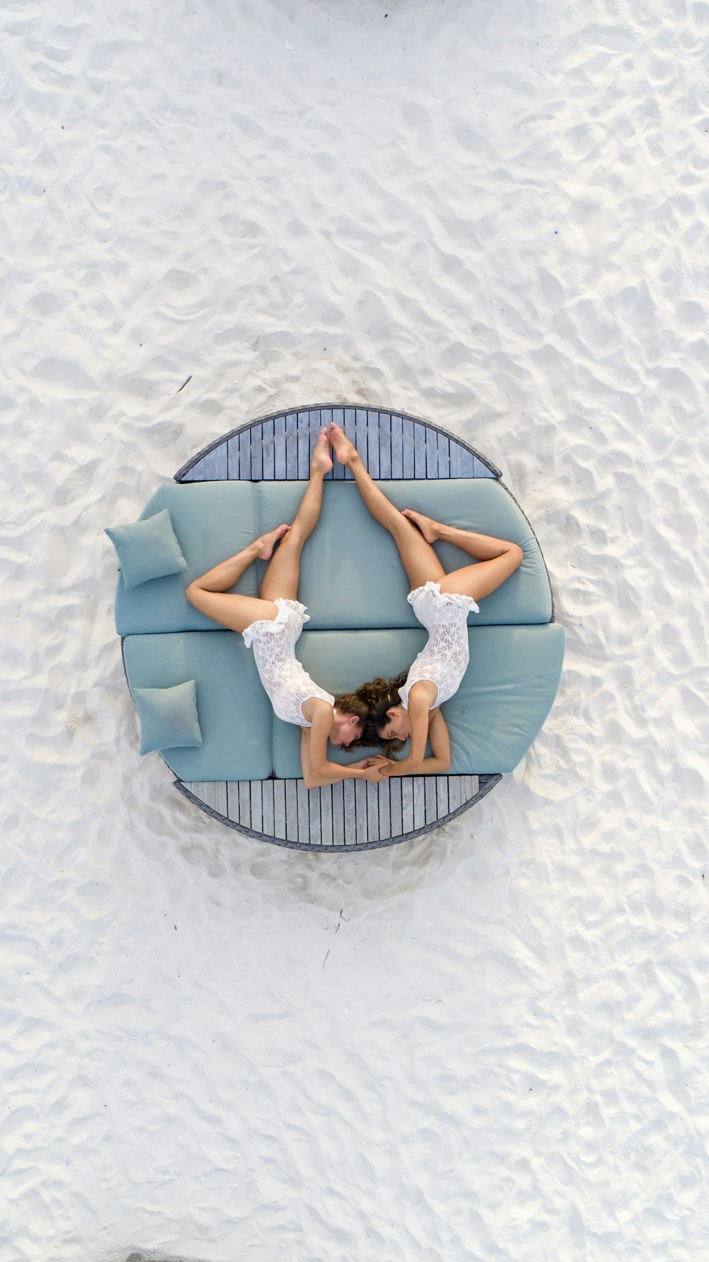 two woman lying on mattress