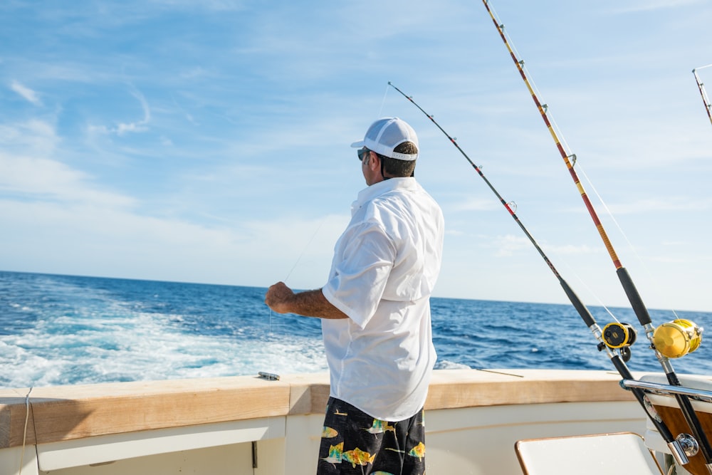 man standing on boat near fishing rods