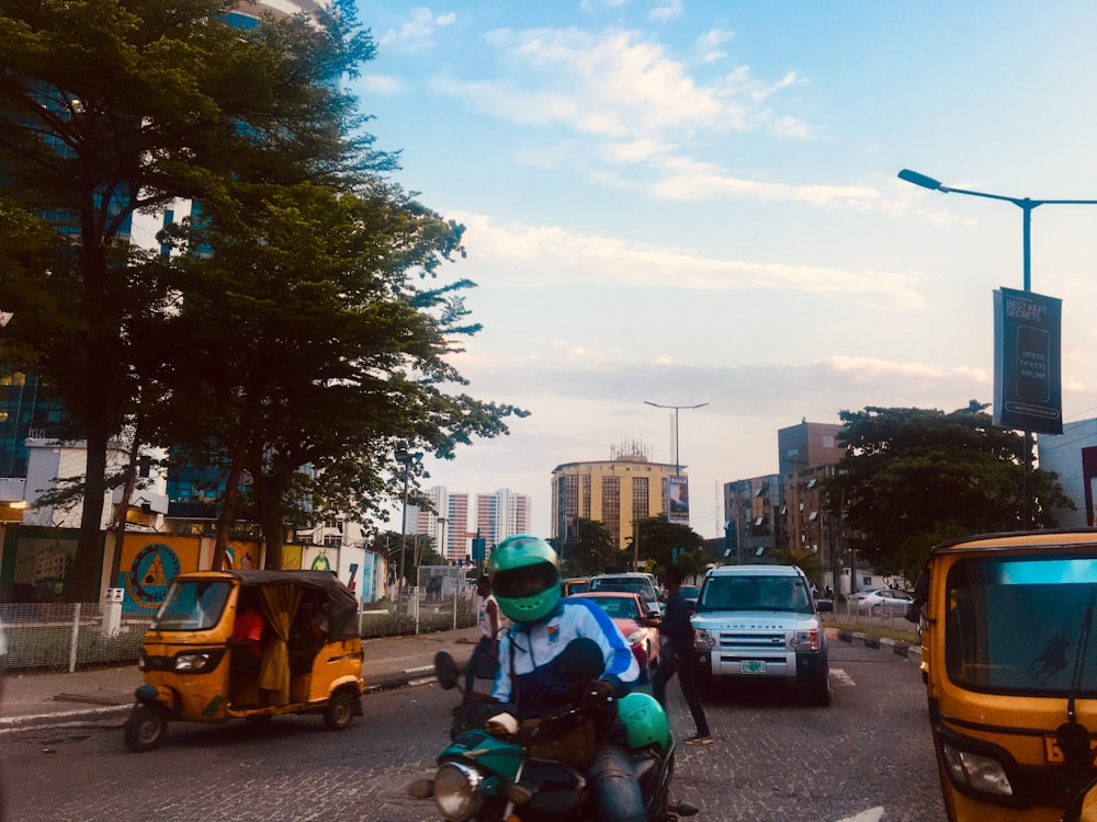 man riding on motorcycle wearing teal helmet