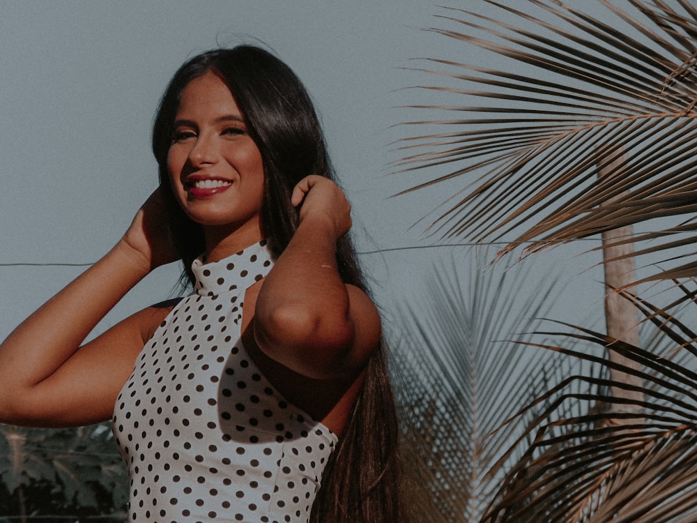 smiling woman touching her hair with both her hands