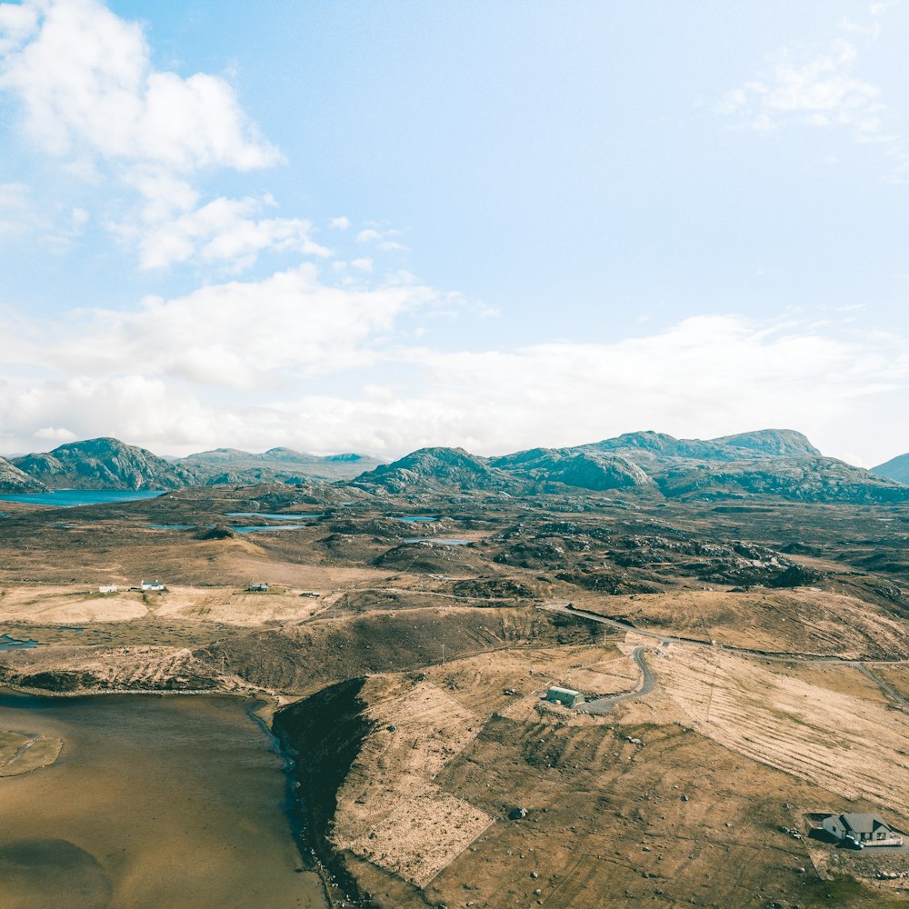 an aerial view of a mountain range with a lake in the foreground