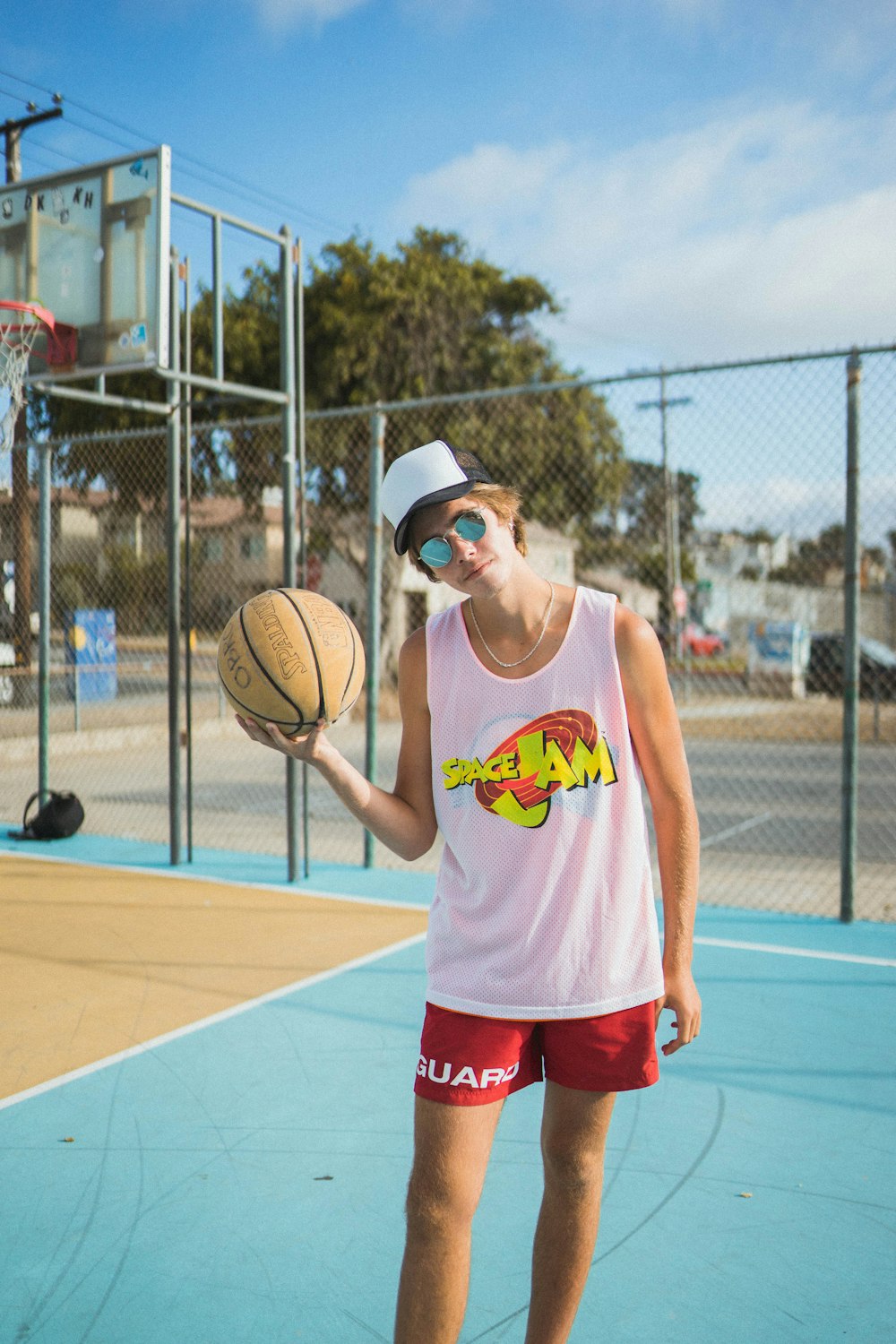 man wearing white tank top and red shorts
