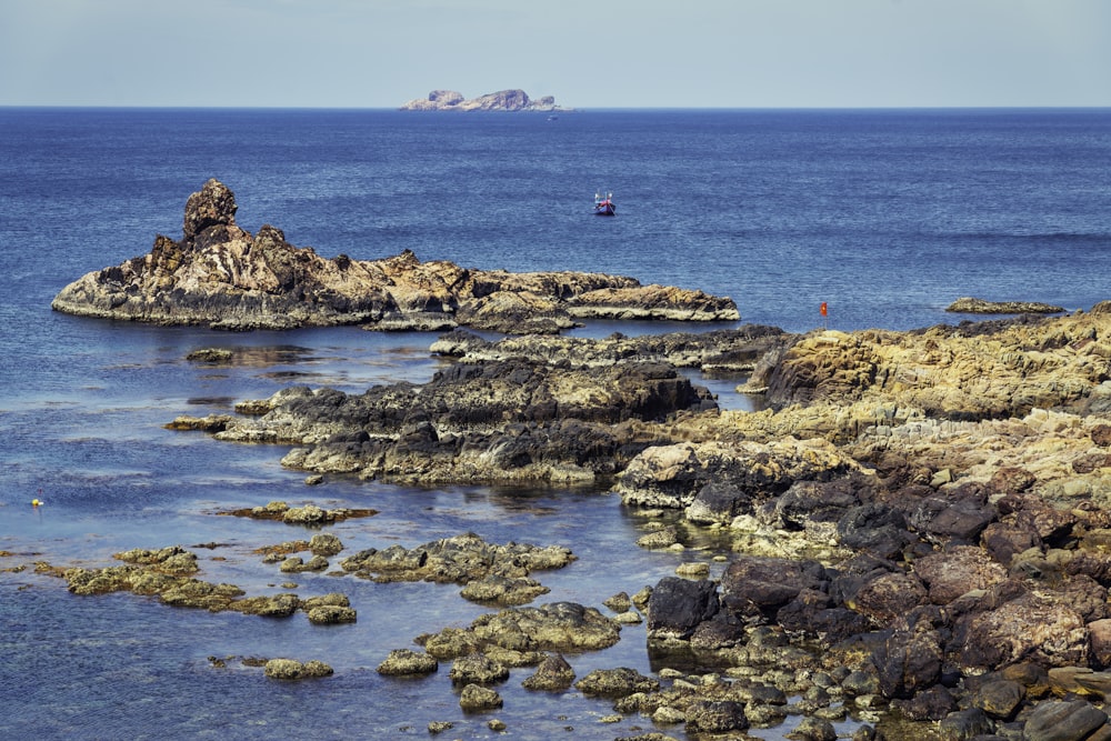 brown rock formations beside body of water