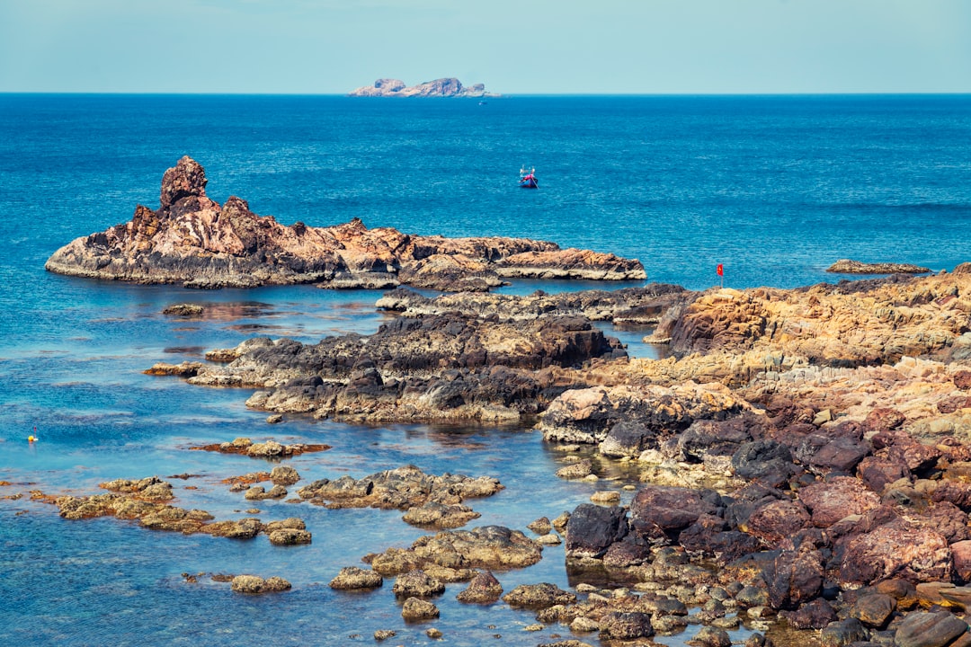 brown rock formations beside body of water