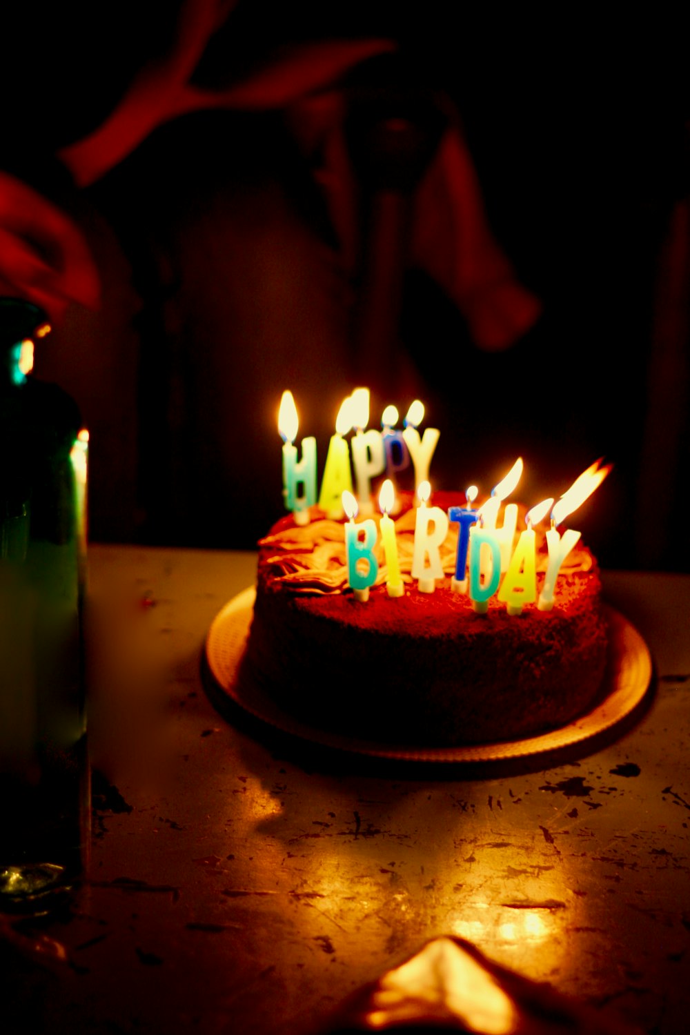 brown icing-covered cake with lighted candles
