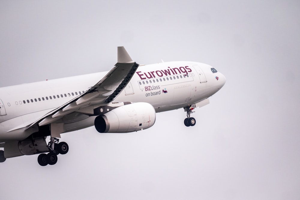 a large jetliner flying through a cloudy sky