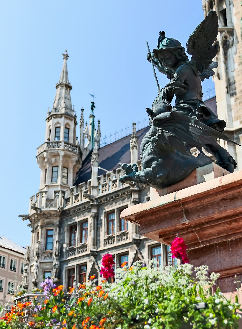 Blumen vor schwarzer Statue und Gebäude
