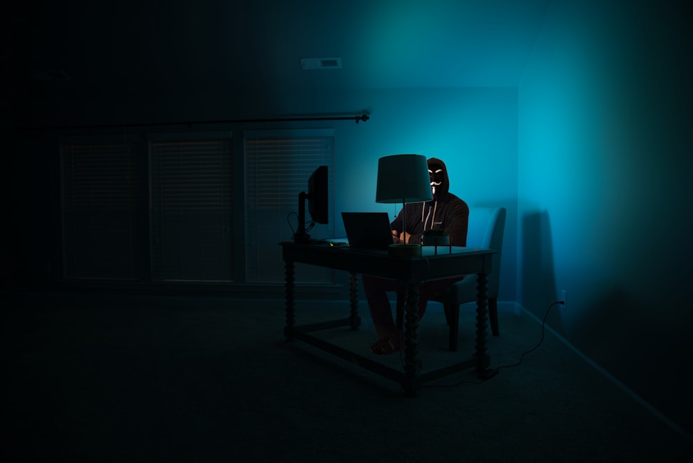 hombre sentado frente a la computadora portátil
