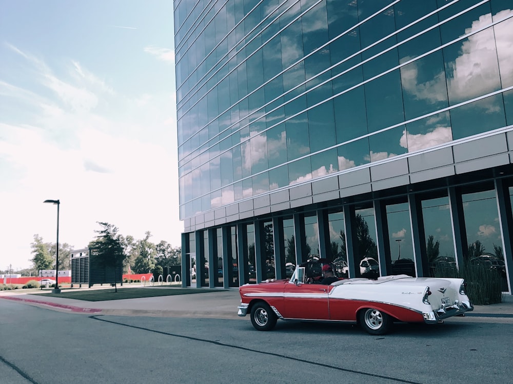 person riding white and red classic convertible coupe on the road