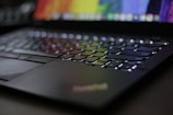 Close-up of a sleek modern laptop keyboard with colorful backlighting.