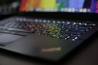 Close-up of a sleek laptop keyboard with glowing keys, highlighting modern computing technology.