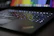 Close-up of a sleek gaming laptop with colorful backlit keyboard in action.