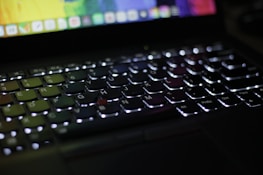 A close-up of a laptop keyboard with backlit keys.
