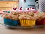 Close-up of a colorful spread of easy-to-make mom recipes, including muffins, cookies, and a bowl of fresh berries.