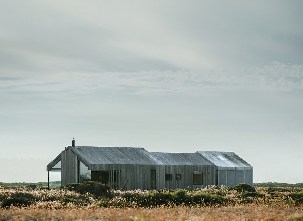 gray wooden building in the middle of the field