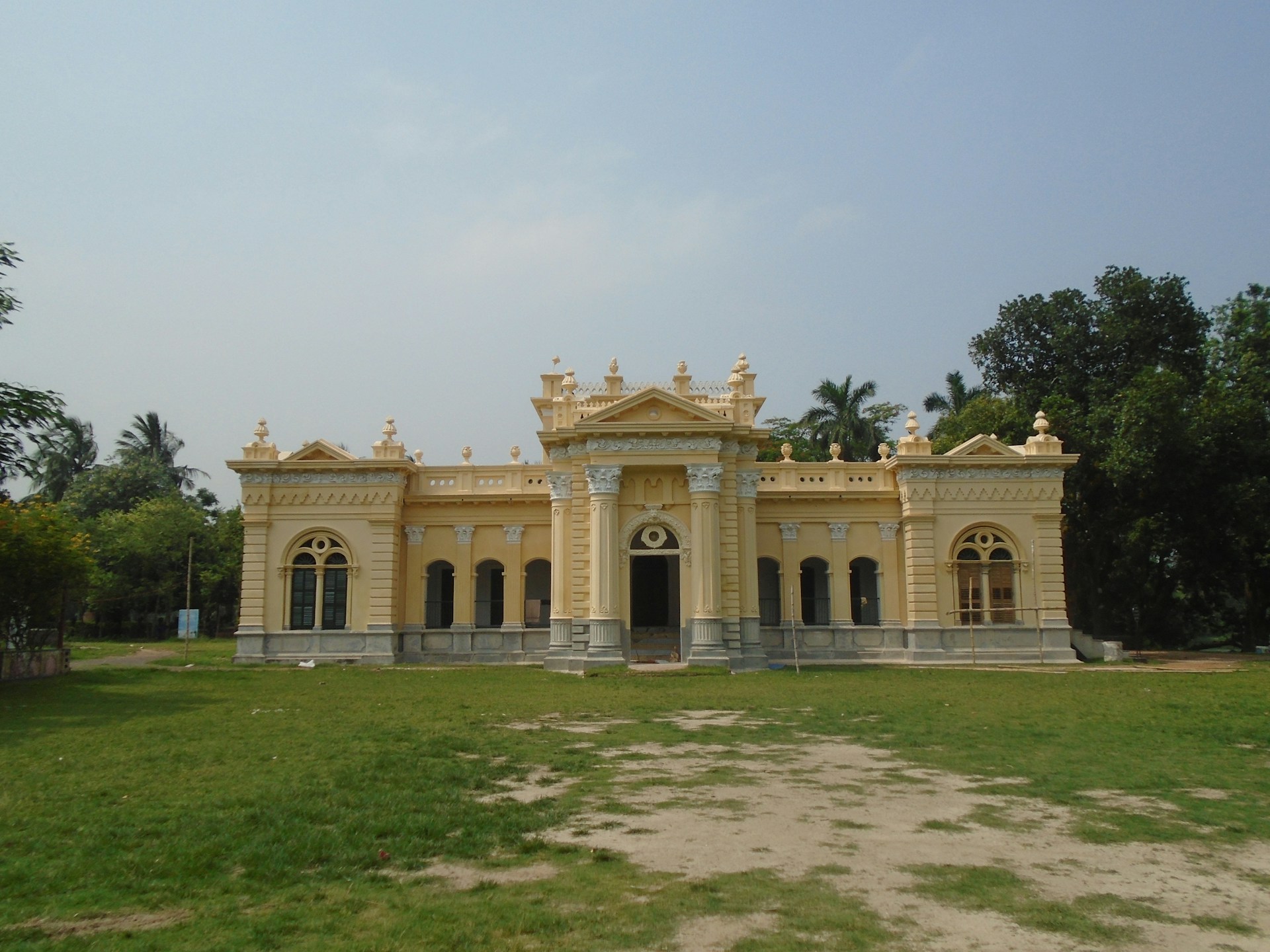 yellow concrete building near trees during daytime