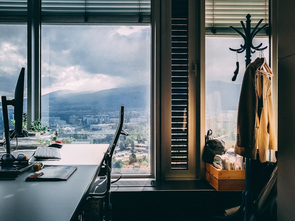 brown coat on hanger stand near window