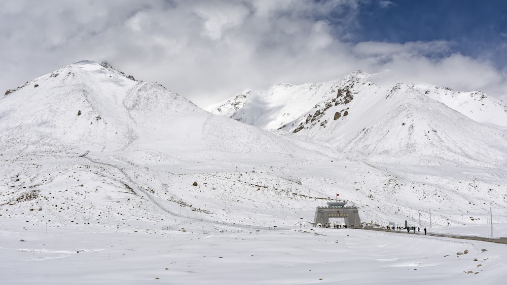 Haus in der Nähe des Feldes mit Blick auf den schneebedeckten Berg