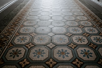 Artisan laying intricate patterned tile flooring with precision and care.