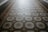 An ornate tiled floor with a hexagonal pattern, featuring intricate designs in shades of blue and beige. The central motif of each tile includes floral elements outlined in different colors.