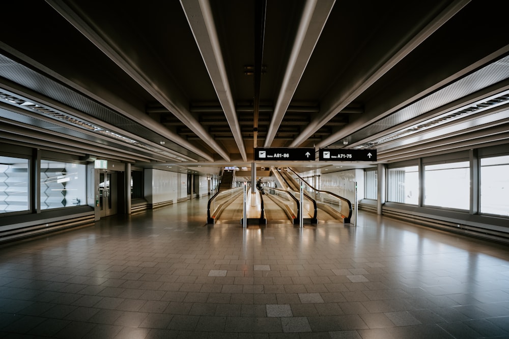 concrete pathway inside building viewing escalator with no people