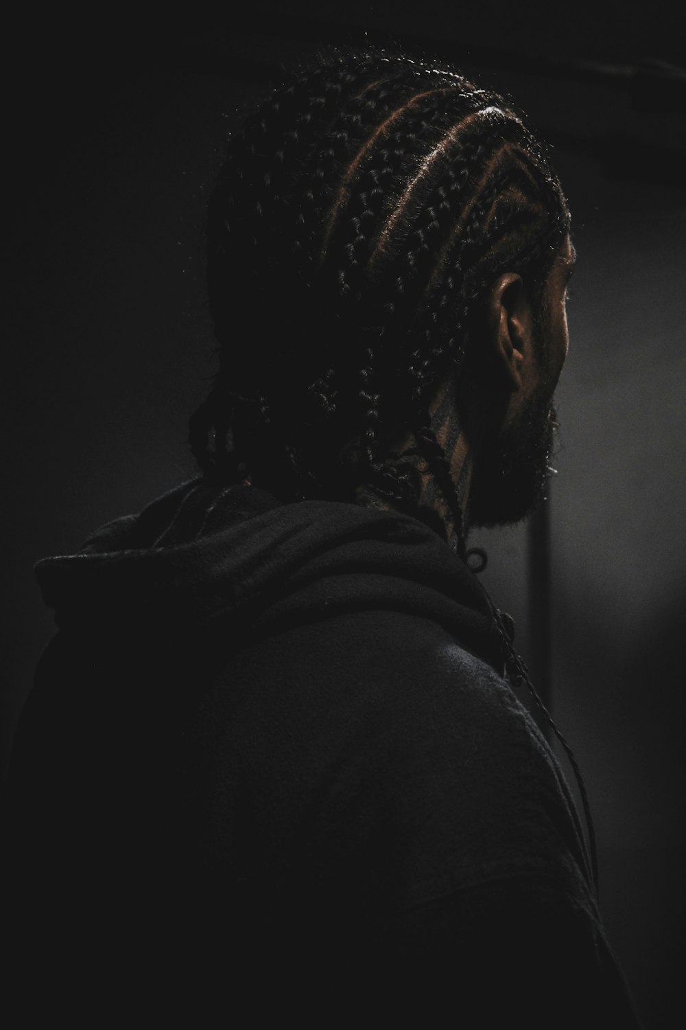 grayscale photography of man wearing hooded jacket facing back