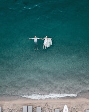 man and woman floating on blue beach