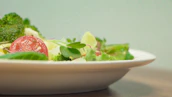Close-up of a healthy meal with fresh vegetables and vibrant colors on a white table.