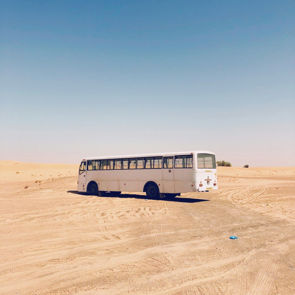 white bus on desert during daytime