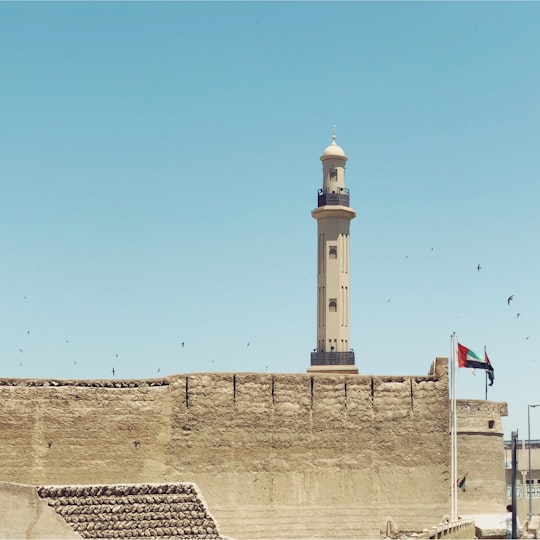 beige concrete castle under blue sky in Dubai Creek United Arab Emirates