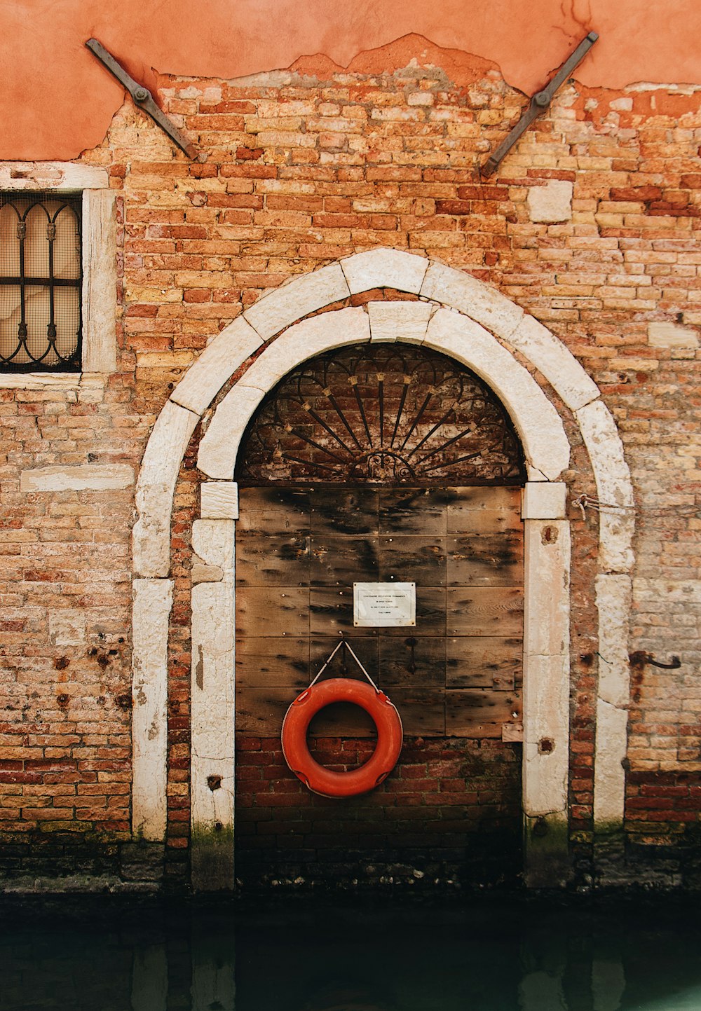 a red life preserver in front of a brick building