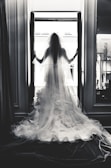 A full-length shot of a flowing silk wedding dress with a subtle train in soft natural light.