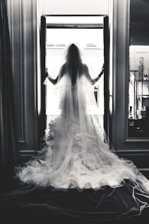Artistic shot of a wedding dress train flowing gracefully across a marble floor.