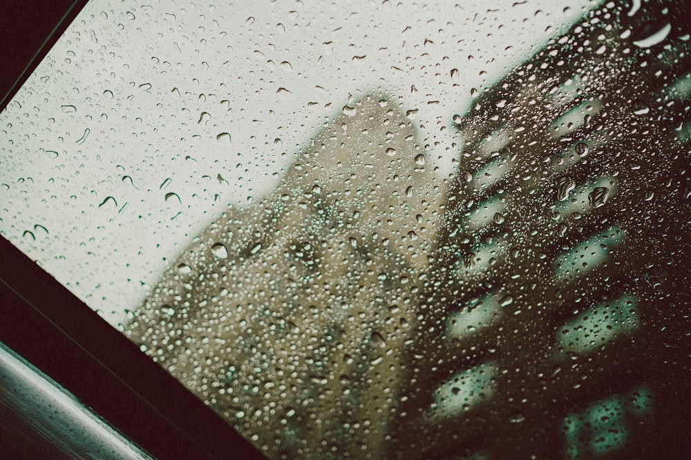 a view of a building through a rain covered window