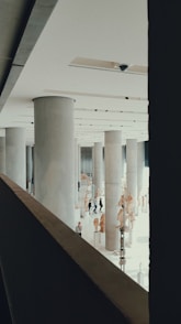 view of people walking inside building with columns
