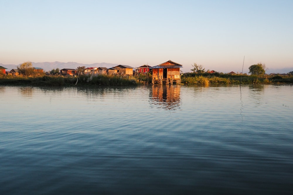 brown houses beside body of water