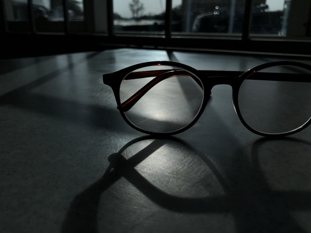 black framed eyeglasses on gray surface