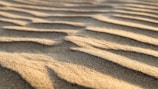 Image capturing fine sand texture in sunlight with construction tools nearby