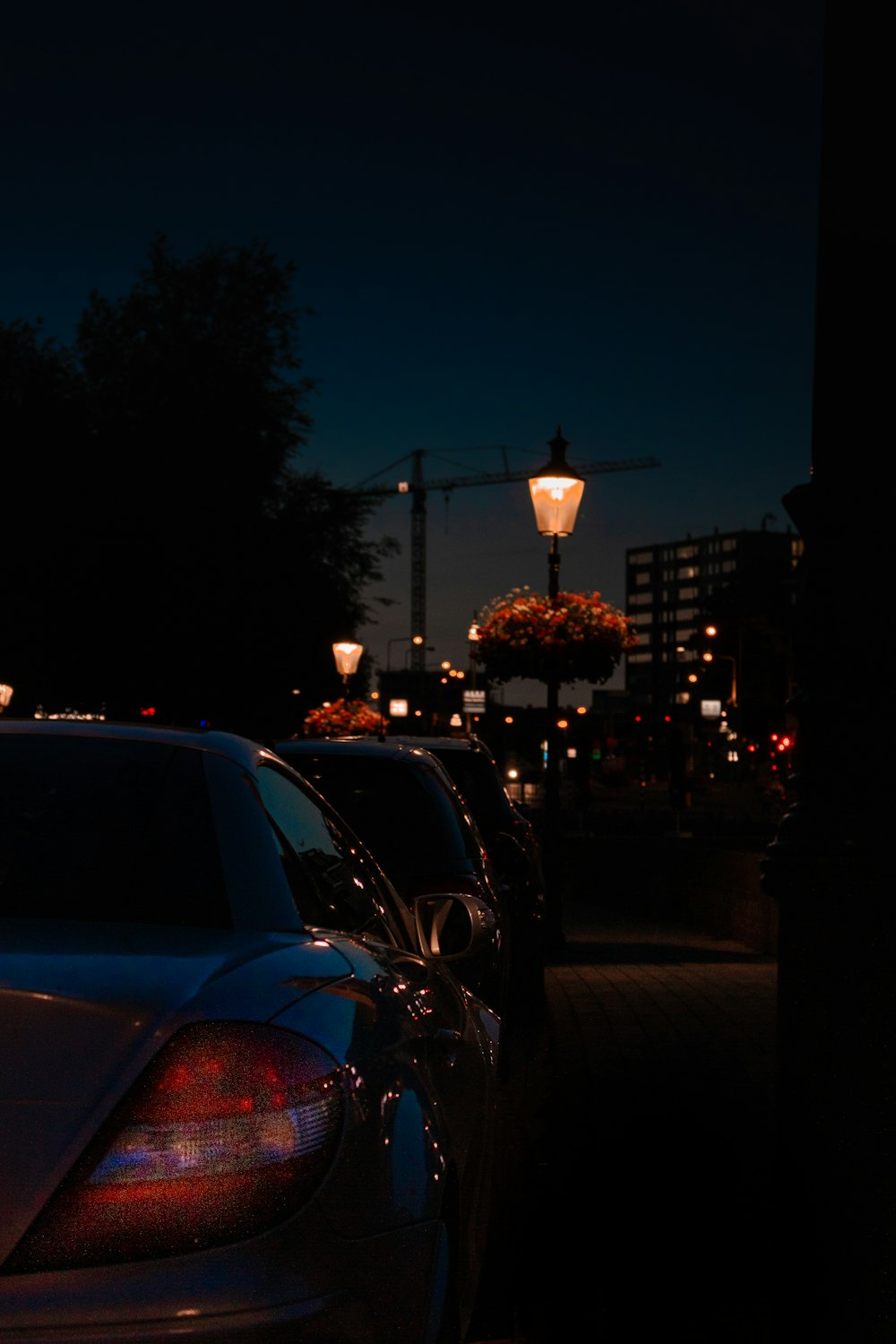 vehicles park at the side of the street during nighttime