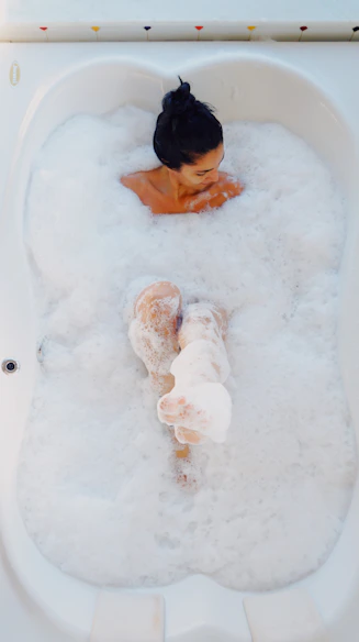 photography of woman on bathtub covered with white bubbles