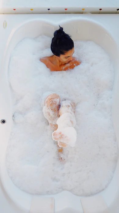 photography of woman on bathtub covered with white bubbles